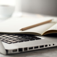 Closeup of Workspace with Modern Creative Laptop, Cup of Coffee and Pencils. Horizontal with Copy Space.